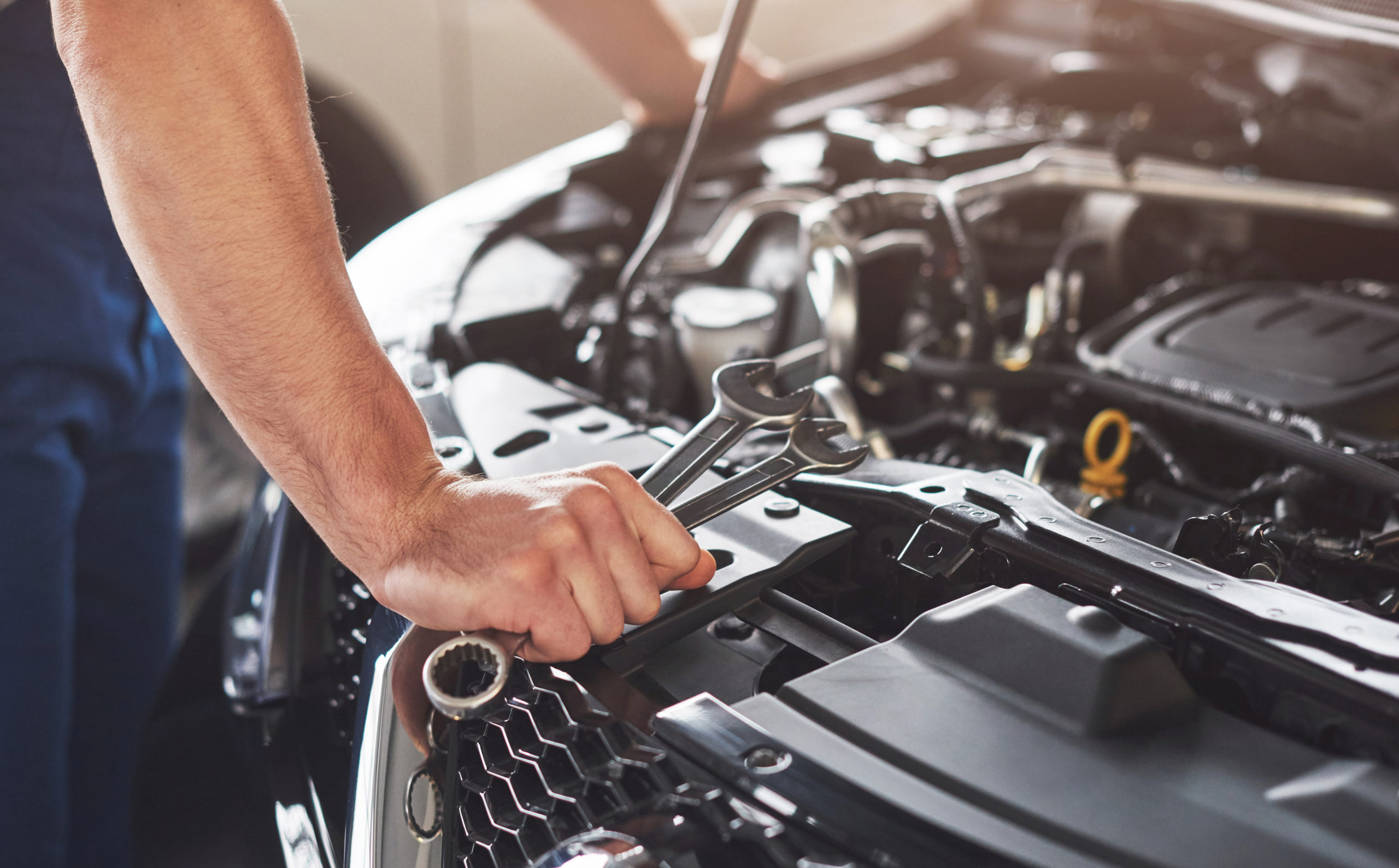 Muscular car service worker repairing a vehicle